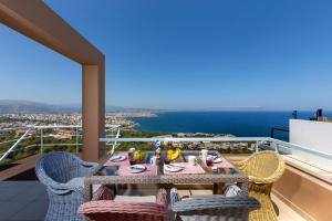 einen Tisch und Stühle auf einem Balkon mit Meerblick in der Unterkunft Unlimited Blue in Chania