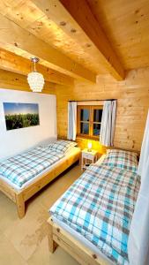 um quarto com 2 camas num chalé de madeira em Ferienhaus Seerose em Übersee