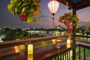 a balcony with a view of a river at night at Bella Premier Hotel & Rooftop Skybar in Hanoi