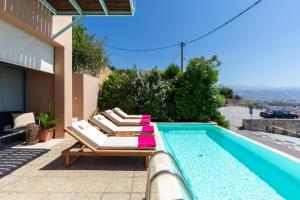 a group of lounge chairs sitting next to a swimming pool at Unlimited Blue in Chania Town