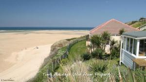 a house on the beach next to a sandy beach at F74 Chyandour, Riviere Towans in Hayle