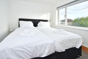 two white beds in a room with a window at Sweetbriar House - By Sigma Stays in Crewe