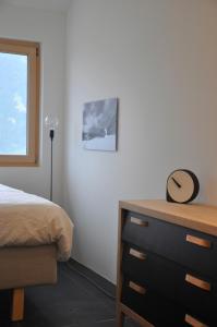 VellaにあるPanoramic Ecodesign Apartment Obersaxen - Val Lumnezia I Vella - Vignogn I near Laax Flims I 5 Swiss stars ratingのベッドルーム1室(ベッド1台、ドレッサー、帽子付)