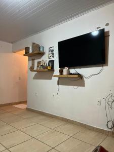 a flat screen tv hanging on a wall at Legítima casa de praia in Capão da Canoa