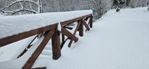eine schneebedeckte Holzbrücke in der Unterkunft Leśniczówka Kalina in Wetlina