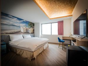 Schlafzimmer mit einem Bett, einem Schreibtisch und einem TV in der Unterkunft Good Time Boutique Hotel in Kaohsiung