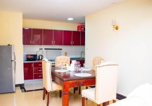 eine Küche mit einem Holztisch und weißen Stühlen in der Unterkunft Wonderstay in Nairobi