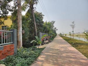 a walkway next to a house and a canal at Aaira Manjil Guest House in Dhaka