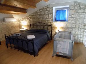 1 dormitorio con cama y pared de piedra en Buen Retiro Modica, en Módica