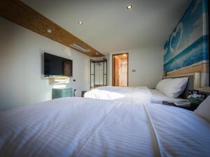 A bed or beds in a room at Good Time Boutique Hotel