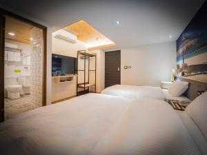 A bed or beds in a room at Good Time Boutique Hotel