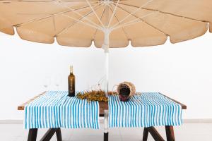 una mesa con sombrilla y una botella de vino en Villa Fariones, en Tías