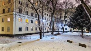 une rue enneigée devant un bâtiment dans l'établissement Warsaw's Vibes Apartment, à Varsovie