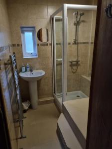a bathroom with a shower and a sink at Maryland Cottage Nr Gatwick in Godstone