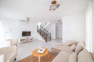 a white living room with a couch and a table at Villa Fariones in Tías