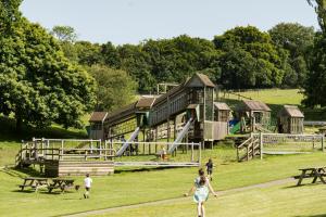 a group of people walking in front of a playground at Maryland Cottage Nr Gatwick in Godstone