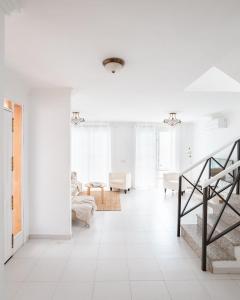 a white living room with white floors and a staircase at Villa Fariones in Tías +33 photos