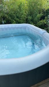 a bath tub with blue water in it at ღ L'Escale bleu • Villa avec Jacuzzi et Baby-foot in Aytré