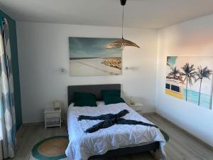 a bedroom with a bed and a painting on the wall at ღ L'Escale bleu • Villa avec Jacuzzi et Baby-foot in Aytré +66 photos