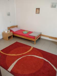 1 dormitorio con 1 cama con alfombra roja en Acke Kum 3, en Žitorađa