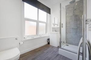 a white bathroom with a shower and a window at Cozy Home in Avenue Terrace, Sleeps 8 in Sunderland
