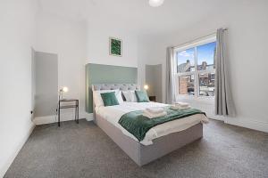 um quarto com uma cama grande e uma janela em Cozy Home in Avenue Terrace, Sleeps 8 em Sunderland