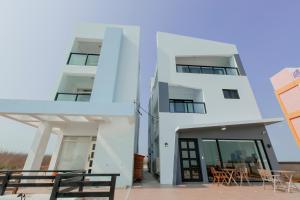 a white building with tables and chairs in front of it at snoozinn in Huxi