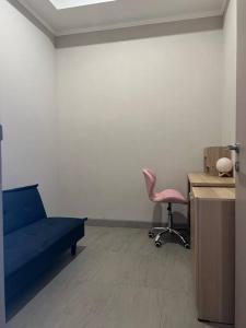 une chambre d'hôpital avec un lit bleu et une chaise rose dans l'établissement 2BR JIExpo Menara Jakarta (new), à Jakarta