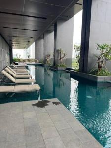 a pool of water with benches in a building at 2BR JIExpo Menara Jakarta (new) in Jakarta
