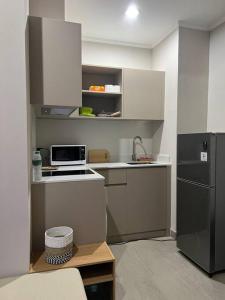 a small kitchen with a sink and a refrigerator at 2BR JIExpo Menara Jakarta (new) in Jakarta