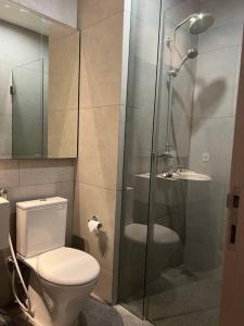 La salle de bains est pourvue de toilettes et d'une douche en verre. dans l'établissement 2BR JIExpo Menara Jakarta (new), à Jakarta