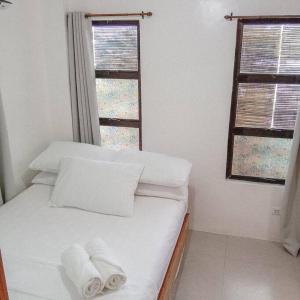 1 dormitorio con 1 cama con 2 toallas en 1-BR flat with kitchen private bath hot and cold shower, en General Luna