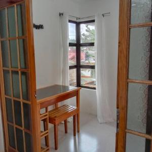 um quarto com uma mesa de madeira e uma janela em 1-BR flat with kitchen private bath hot and cold shower em General Luna