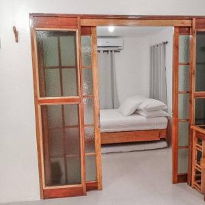 Pokój z łóżkiem piętrowym i szklanymi drzwiami w obiekcie 1-BR flat with kitchen private bath hot and cold shower w mieście General Luna
