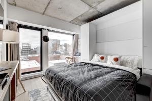 um quarto com uma cama grande e uma janela grande em Magnifique Studio au centre-ville à 5 min à pied de tout em Montreal