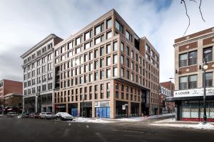 um grande edifício numa rua da cidade com carros estacionados em frente em Magnifique Studio au centre-ville à 5 min à pied de tout em Montreal