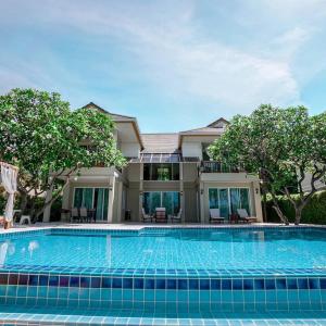 a large swimming pool in front of a house at SeaRidge Hua Hin Resort & Poolvilla in Khao Tao