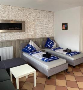 2 sofás en una sala de estar con almohadas azules y blancas en Family Apartments Lübeck en Lübeck