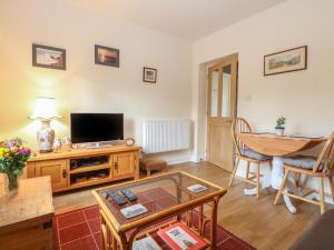 a living room with a television and a table at The Annexe in Fakenham