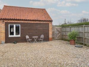 a backyard with two chairs and a shed at The Annexe in Fakenham