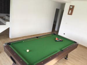 a green pool table with a pile of balls on it at Sanda GuestHouse in Antsirabe