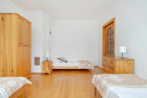 1 dormitorio con 2 camas y armario de madera en Apartament Jaszczurówka, en Zakopane