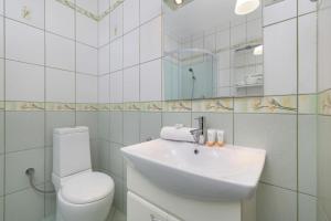 a white bathroom with a sink and a toilet at Apartament Jaszczurówka in Zakopane