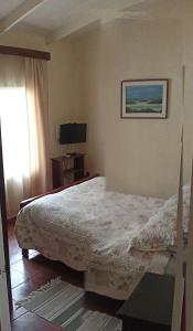 1 dormitorio con 1 cama y TV en Cabañas La Querencia de Algarrobo, en Algarrobo