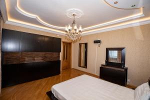 Habitación grande con cama y lámpara de araña. en WAQAS RESIDENCE INTERNATIONAL, en Baku