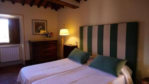 a bedroom with a large white bed with two pillows at Villa Le Barone in Panzano