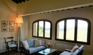 a living room with a couch and two windows at Villa Le Barone in Panzano