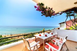 a table and chairs on a balcony with a view of the beach at Athena's Veranda magestic views Home 97 in Glyfada of Corfu by New Era in Glyfada +23 photos