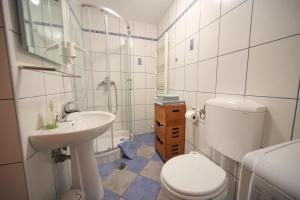 a white bathroom with a toilet and a sink at Apartma Felix in Kranjska Gora