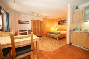 a bedroom with a bed and a kitchen with a table at Apartma Felix in Kranjska Gora